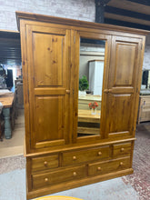 Load image into Gallery viewer, A spacious solid pine triple wardrobe offering excellent storage capacity. Features one hanging rail, two short dovetail-jointed drawers, and three long drawers for versatile organisation. The piece is structurally sound with minor surface marks consistent with use. Designed for practicality, it dismantles into panels (excluding the drawer section) to simplify moving and placement. An ideal choice for those seeking substantial storage with traditional craftsmanship.

Delivery Available

Overall Dimensions


