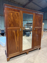 Load image into Gallery viewer, A well-preserved Edwardian mahogany wardrobe built to last, with solid construction throughout. The double cupboard houses a hanging rail and multiple hooks for versatile storage. It also has two shelves to accommodate folded garments, two compact dovetail-jointed drawers and one full-length drawer offer practical organisation. The finish bears gentle signs of age with minor marks that reflect its authentic heritage. Includes the original key. An excellent choice for those seeking genuine period furniture w
