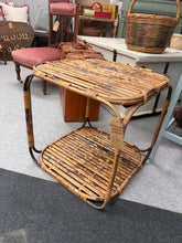 Load image into Gallery viewer, A charming wicker side table with sturdy construction and practical lower shelf storage. Perfect for adding warmth and functionality to any room. Well-maintained and ready to enhance your home décor.

Delivery Available

Overall Dimensions

48cm wide x 48cm deep x 49cm high

