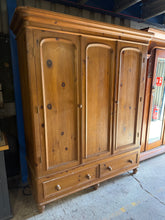 Load image into Gallery viewer, This charming vintage pine triple wardrobe combines practical storage with timeless character. Structurally sound and in good overall condition, it features a long hanging rail and two dovetail-jointed drawers—perfect for organising clothing and accessories. Light wear adds to its authentic vintage appeal. Designed for convenience, it disassembles into three sections for straightforward moving and positioning in your home.

Delivery Available

Overall Dimensions

168cm wide x 60cm deep x 199cm high

