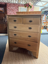 Load image into Gallery viewer, A beautifully stripped wooden chest of drawers, restored to its natural finish. Features authentic dovetail jointed construction with practical storage: two shallow drawers above three deep drawers. The bare wood invites personalisation—apply wax or finish to suit your décor and protect the surface. Ideal for bedrooms, hallways, or living spaces seeking character and functionality.

Delivery Available

Overall Dimensions

92cm wide x 43cm deep x 108cm high

