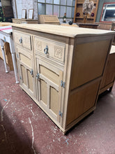 Load image into Gallery viewer, This striking oak sideboard showcases beautiful natural grain after being stripped back to bare wood. The piece features two dovetail-jointed drawers positioned above a spacious double cupboard with internal shelf, offering practical storage for any room. Structurally sound and in good condition, it would benefit from a protective coat of wax to enhance the wood and ensure longevity. A versatile addition to period or contemporary interiors.

Delivery Available

Overall Dimensions

97cm wide x 51cm deep x 85
