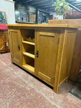 Load image into Gallery viewer, A characterful oak sideboard combining practical storage with timeless appeal. Two enclosed cupboards with shelving provide discreet space for tableware and essentials, while the central open shelving displays glassware and wine bottles beautifully. Structurally sound with the honest patina of use—minor marks add to its authentic charm. Ideal for dining rooms or living spaces where storage meets style.

Delivery Available

Overall Dimensions

112cm wide x 34cm deep x 75cm high

