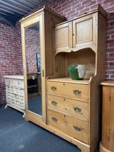 Load image into Gallery viewer, This exceptional Victorian pine compactum combines authentic period charm with practical functionality. Structurally sound and in excellent overall condition, it offers generous storage versatility with a hanging rail, multiple hooks, a small double cupboard, and three beautifully crafted dovetail-jointed drawers. The piece disassembles into three sections for convenient transportation and repositioning. Characteristic patina and minor marks reflect its age and heritage, adding to its authentic appeal. An i
