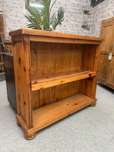 Load image into Gallery viewer, A charming rustic wooden bookcase with solid construction and authentic character. This piece features one fixed shelf, ideal for displaying books and decorative items. Minor surface marks add to its vintage appeal and rustic charm. A practical storage solution with timeless style.

Delivery Available

Overall Dimensions

97cm wide x 28.5cm deep x 86cm high

