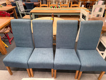 Load image into Gallery viewer, A set of four blue upholstered dining chairs in sound structural condition. Each chair is ready for use, with minor cosmetic marks that can be easily cleaned. One chair features a small tear that is barely visible. Ideal for those seeking affordable seating with character and potential.

Delivery Available

Overall Dimensions

approx : 47cm wide x 49cm deep x 103cm high&nbsp;

