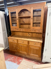 Load image into Gallery viewer, Built from solid pine with sturdy dovetail joinery throughout, this dresser delivers substantial storage capacity. The top section includes six drawers, two cupboards, and two shelves, while the base features three more drawers plus a double and single cupboard. In good working order with the honest wear you'd expect from a piece with history, it's free from major damage. Designed to separate into two parts for convenient handling and placement in your home.

Delivery Available

Overall Dimensions

152cm wi
