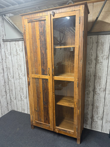 This beautiful linen press / larder unit combines practicality with a charming, unique design. Crafted from multiple woods, it is structurally sound and in great overall condition, ready to enhance your home storage. Inside, three spacious long shelves provide ample room for organizing linens, pantry items, or kitchen essentials. The design stands out with one door featuring glass, perfect for displaying your favorite items, while the other door is solid wood, hiding away less decorative belongings. A versa