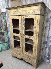 Load image into Gallery viewer, This charming distressed wooden cupboard combines vintage character with practical functionality. Structurally sound and well-maintained, it features two internal shelves and comes complete with its original key. The natural wear marks enhance its authentic appeal, making it an ideal choice for storing linens, pantry items, or displaying treasured collections. A versatile addition to period homes or those seeking distinctive storage solutions.

Delivery Available

Overall Dimensions

104cm wide x 40cm deep 
