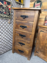 Load image into Gallery viewer, Crafted from solid wood, this rustic tallboy combines timeless character with practical storage. Five spacious drawers provide ample room for clothing, linens, or personal items. The piece bears the natural signs of use—subtle marks and weathering that enhance its authentic charm. Structurally sound and ready to become a distinctive focal point in any bedroom or living space.

Delivery Available

Overall Dimensions

61cm wide x 45.5cm deep x 122cm high

