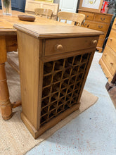Load image into Gallery viewer, A sturdy pine wine rack designed to store up to 30 bottles. Features a single dovetail-jointed drawer for keeping wine accessories and extras within reach. The piece shows some minor surface marks consistent with use, though the construction remains solid and reliable. An understated addition to any kitchen or dining space.

Delivery Available

Overall Dimensions

58.5cm wide x 26cm deep x 82.5cm high

