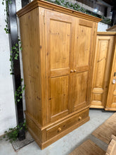 Load image into Gallery viewer, This beautiful solid pine wardrobe is sturdy and well-maintained. While it shows some signs of use with a few scratches, these can easily be refreshed with a bit of paint. It offers plenty of storage space, featuring a hanging rail and a dovetail jointed drawer. Plus, it can be dismantled for convenient moving.

Overall Dimensions

122cm wide x 63cm deep x 191cm high

DELIVERY AVAILABLE      

HAVE THIS PAINTED A COLOUR OF YOUR CHOICE FOR AN EXTRA £100 OR HAVE IT COMPLETELY STRIPPED BACK FOR JUST £120    


