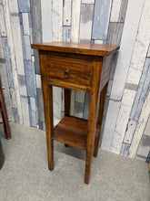 Load image into Gallery viewer, This charming hardwood side table combines practical storage with timeless appeal. Featuring a single drawer and lower shelf, it offers convenient space for books, remotes, or decorative items. Built to last, the solid construction shows gentle signs of age and use that add character rather than detract from its functionality. An ideal accent piece for bedrooms, living rooms, or hallways seeking warmth and utility.

Delivery Available

Overall Dimensions

35cm wide x 34.5cm deep x 82cm high

