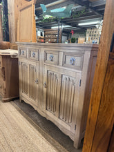 Load image into Gallery viewer, A beautiful stripped oak sideboard with authentic character and generous storage. Features two dovetail-jointed drawers above a spacious double cupboard, offering practical organisation for any room. The natural wood finish showcases the oak's grain and warmth, though a protective coat of wax is recommended to maintain its appearance. Structurally sound and in excellent condition, this piece combines classic craftsmanship with everyday functionality.

Delivery Available

Overall Dimensions

115cm wide x 45c

