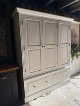 Load image into Gallery viewer, A sturdy solid pine triple wardrobe with practical storage across three sections. The double cupboard features one hanging rail, while the single cupboard offers two shelves for folded items. Two spacious dovetail-jointed drawers sit beneath for additional storage.
This piece has minor surface marks and age-related wear are consistent with its pre-loved status. Fully dismantles for convenient transport and repositioning. Ideal for those seeking authentic, well-crafted storage with a rustic appeal and room f
