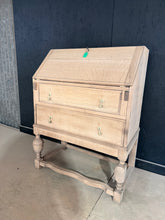 Load image into Gallery viewer, This stripped oak bureau showcases authentic vintage craftsmanship with its natural wood finish and traditional dovetail-jointed drawers. The pull-down writing desk provides functional workspace, while two generous storage drawers keep essentials organised. As a stripped piece, it may benefit from a protective wax coat to enhance the wood's character and durability. Minor wear to one leg is present but does not impact everyday use. A distinctive addition for those who appreciate honest, well-made furniture 
