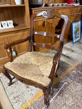 Load image into Gallery viewer, A charming French-inspired oak carver chair featuring a traditional rush seat. This pre-loved piece shows gentle signs of age with minor surface marks that add to its character. Ideal for creating a cosy corner in a bedroom or study, it combines classic elegance with practical comfort.

Delivery Available

Overall Dimensions

approx : 67cm wide x 54cm deep x 94cm high

