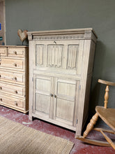 Load image into Gallery viewer, A beautiful stripped oak drinks cabinet with authentic character. Features a pull-down cupboard above a spacious double cupboard base, perfect for storing glassware and bottles. The natural wood finish showcases the oak's grain and warmth—apply wax for added protection and lustre. Decorative key only and does not function. An elegant addition to any dining room or living space.

Delivery Available

Overall Dimensions

80cm wide x 48cm deep x 123cm high
