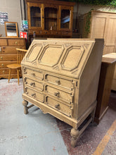 Load image into Gallery viewer, A beautiful stripped oak bureau with authentic character. This piece features a pull-down writing desk, two short dovetail-jointed drawers, and two longer drawers below—ideal for home office storage and workspace. The natural wood finish shows gentle signs of age and use, adding to its charm. A protective coat of wax is recommended to maintain the wood. A striking focal point for any study or bedroom.

Delivery Available

Overall Dimensions

93cm wide x 53cm deep x 112cm high

