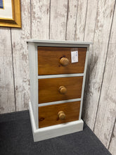 Load image into Gallery viewer, This striking solid pine bedside table combines timeless craftsmanship with practical storage. Three dovetail-jointed drawers provide secure, ample space for essentials, while the sophisticated grey-blue surround contrasts beautifully with rich oak-toned drawers. Built to last, this piece brings both character and functionality to any bedroom.

Delivery Available

Overall Dimensions

42cm wide x 46cm deep x 74.5cm high

