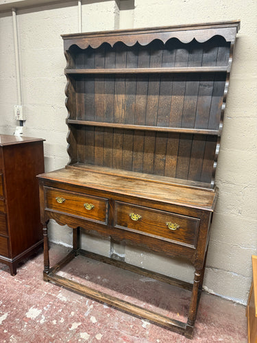 This charming early 20th-century oak dresser by Hooper & Co features two spacious dovetail-jointed drawers and an open base with a handy plate rack for extra storage. While it shows some signs of use, a good polish will bring out its beauty. There is a small missing trim piece, but it can be easily replaced. Plus, the top separates from the base, making it simpler to move.

Overall Dimensions

125cm wide x 47cm deep x 194cm high

DELIVERY AVAILABLE      

HAVE THIS PAINTED A COLOUR OF YOUR CHOICE FOR AN EXT
