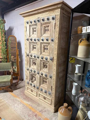 This stunning hardwood studded cupboard is a true statement piece with its unique metal-studded finish that adds character and charm to any room. Crafted from solid hardwood, it is exceptionally sturdy and impressively heavy, promising durability that lasts for years. Inside, you’ll find three spacious shelves perfect for organizing your belongings, along with two convenient drawers at the base for additional storage. Whether used as a wardrobe or cupboard, this one-of-a-kind item brings a happy blend of st