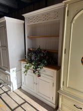 Load image into Gallery viewer, A charming pine farmhouse dresser with authentic character and solid construction. Features two open shelves above two dovetail-jointed drawers and a double cupboard, offering generous storage for kitchen or dining room display. The piece shows pleasant signs of use with minor marks that enhance its vintage appeal. Splits into two sections for convenient transport and placement. Ideal for those seeking genuine farmhouse style with practical functionality.

Delivery Available

Overall Dimensions

117cm wide 
