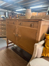 Load image into Gallery viewer, A striking oak Art Deco sideboard, stripped to reveal its natural grain and warm patina. Features two spacious dovetail-jointed drawers above a double cupboard with shelving—ideal for displaying treasures or storing essentials. Structurally sound and ready for finishing. A light wax coat will enhance protection and lustre. Perfect for adding period character to any room.

Delivery Available

Overall Dimensions

121cm wide x 48cm deep x 96.5cm high

