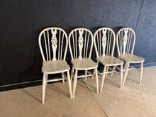 Load image into Gallery viewer, A charming set of 4 wheelback dining chairs finished in gloss white. Each chair bears the character of its history, with light patina and minor marks that enhance their vintage appeal. Structurally sound and in good overall condition, these pieces combine classic design with authentic period charm. Perfect for adding character to any dining space.

Delivery Available

Overall Dimensions

approx : 32cm wide x 41cm deep x 90.4cm high

