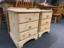 Load image into Gallery viewer, A charming pair of solid pine bedside tables, stripped back to reveal natural wood grain and character. Each unit features three practical drawers for storage. Structurally sound and in excellent condition. The natural finish invites personalisation — a coat of wax or your chosen stain will enhance protection and colour. Perfect for rustic, farmhouse or contemporary interiors seeking authentic wooden furniture with genuine patina.

Delivery Available

Overall Dimensions

46.5cm wide x 45cm deep x 63.5cm hig
