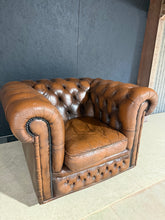 Load image into Gallery viewer, A timeless Chesterfield club chair in rich brown leather, offering classic elegance and enduring comfort. This piece is structurally sound and in good condition, with a well-maintained leather finish that will develop beautiful patina with use. The iconic rolled arms and buttoned back exemplify traditional craftsmanship, making it an ideal statement piece for living rooms, studies, or reception spaces. A light leather treatment will restore the natural lustre and enhance its distinguished appearance. Perfec

