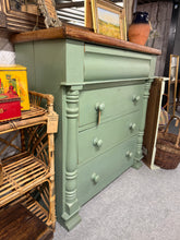 Load image into Gallery viewer, This striking green mahogany chest of drawers combines authentic period craftsmanship with practical storage. Structurally sound and in excellent condition, it features three dovetail-jointed drawers plus a hidden secret drawer—perfect for treasured items. A genuine piece sourced from the set of the beloved BBC series Doc Martin, filmed in Port Isaac. A conversation-starting statement piece with real character and heritage.

Delivery Available

Overall Dimensions

100cm wide x 45cm deep x 105cm high

