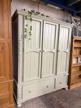 Load image into Gallery viewer, A charming solid pine triple wardrobe offering generous storage space. Features one double cupboard and one single cupboard, both fitted with hanging rails, plus a long and short drawer at the base — ideal for organising clothing and accessories. This well-loved piece shows minor cosmetic wear consistent with age and use, but remains structurally sound and fully functional. Disassembles for convenient transport and storage.

Delivery Available

Overall Dimensions

149cm wide x 54.5cm deep x 183cm high

