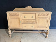 Load image into Gallery viewer, A striking stripped oak sideboard with authentic character and solid construction. This piece has been carefully restored to reveal the natural wood grain, though a protective wax finish is recommended. Features two single cupboards with shelving and two dovetail-jointed drawers offering generous storage. Structurally sound and ready to become a focal point in any room.

Delivery Available

Overall Dimensions

137cm wide x 51cm deep x 95cm + 20cm high


