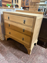 Load image into Gallery viewer, This oak chest of drawers has been stripped back to reveal its natural wood surface, showcasing authentic grain and character. Three spacious drawers feature traditional dovetail joinery, ensuring durability and smooth operation. The unfinished state allows you to customize the final look—apply wax for a natural sheen, stain for deeper colour, or leave as is for a rustic aesthetic.&nbsp;

Delivery Available

Overall Dimensions

76cm wide x 40cm deep x 75.5cm / 80cm high
