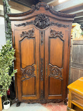 Load image into Gallery viewer, A substantial french style mahogany armoire offering practical storage solutions with one hanging rail and a shelf inside. This pre-owned piece shows its age with light surface marks, yet remains structurally solid and fully functional. The fixed construction ensures stability, whilst the generous interior space makes it ideal for organising clothing and textiles. Its rich wood finish and substantial presence create an impressive statement in any bedroom or dressing area.

Delivery Available

Overall Dimens
