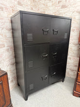 Load image into Gallery viewer, This sturdy black metal cupboard combines practical storage with industrial charm. Built to last, it features six compartments perfect for organising tools, supplies, or household items. Despite its pre-loved status, it remains in solid working condition with only minor cosmetic marks that add to its character. An excellent choice for garages, workshops, or utility spaces where reliable storage matters.

Delivery Available

Overall Dimensions

80cm wide x 40.5cm deep x 113cm high

