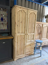 Load image into Gallery viewer, A characterful solid pine wardrobe, stripped back to reveal its natural wood grain. Features one hanging rail, two shelves, and two dovetail-jointed drawers—ideal for storing clothing and accessories. Structurally sound and in good condition. The bare wood finish offers authentic period charm and can be waxed or finished to your preference. Perfect for country, rustic, or farmhouse-style interiors.

Delivery Available

Overall Dimensions

90cm wide x 53cm deep x 179cm high
