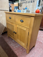 Load image into Gallery viewer, This contemporary oak sideboard is solidly built and in great overall shape. While it has some minor marks from use, they’re hardly noticeable. It features generous storage space with two dovetail-jointed drawers above a double cupboard, which includes one shelf inside.

Overall Dimensions

90cm wide x 34cm deep x 81cm high

DELIVERY AVAILABLE      

For our other items see our website https://fossewayfurniture.co.uk

collection from our shop at CV36 4QZ or purchase online for delivery.

