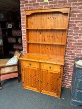 Load image into Gallery viewer, This sturdy solid pine dresser is in good condition overall. It shows some signs of use with marks, but nothing that impacts its use. The top section features 2 shelves above 2 drawers, and the base includes a spacious double cupboard.

Delivery Available

Overall Dimensions

91cm wide x 43cm deep x 176cm high

