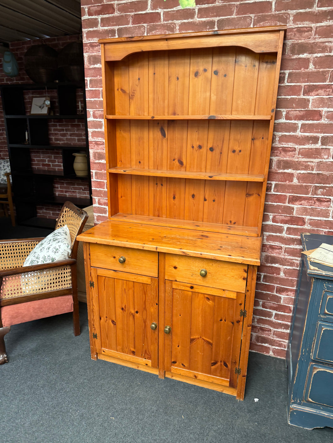 This sturdy solid pine dresser is in good condition overall. It shows some signs of use with marks, but nothing that impacts its use. The top section features 2 shelves above 2 drawers, and the base includes a spacious double cupboard.

Delivery Available

Overall Dimensions

91cm wide x 43cm deep x 176cm high
