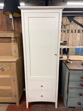 Load image into Gallery viewer, A practical single white wardrobe with clean, modern lines. Structurally sound and in good overall condition, this piece features one hanging rail for garments and two spacious drawers for additional storage. Shows minor wear consistent with use, but remains fully functional and ready for a new home.

Delivery Available

Overall Dimensions

71cm wide x 54cm deep x 188cm high&nbsp;

