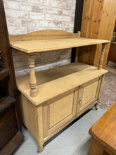 Load image into Gallery viewer, This delightful oak buffet has been carefully stripped back to reveal its natural finish, allowing the rich grain of the wood to shine through. Ideal for adding a warm, rustic touch to any room, it features one spacious shelf above a double cupboard, providing ample storage for your essentials. To keep it looking its best, a coat of wax is recommended for protection and to enhance its natural charm. Perfect for those who love timeless, natural furniture with practical storage options.

Overall Dimensions

1
