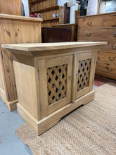 Load image into Gallery viewer, This beautiful hardwood TV unit has been lovingly stripped back to its natural finish, giving it a fresh, authentic look full of character. To keep it looking its best, applying a coat of wax is recommended, which will also help protect the wood. Inside, there’s a convenient shelf that offers extra storage space for your media devices or accessories. Perfect for brightening up your living room with timeless style and practical functionality.

Delivery Available

Overall Dimensions

87cm wide x 42.5cm deep x

