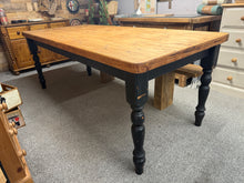 Load image into Gallery viewer, A substantial seven-foot pine dining table built to last, this piece combines authentic character with practical functionality. Finished in black-painted legs that bear the patina of use, it delivers that vintage aesthetic without requiring restoration. Comfortably accommodates eight diners, making it ideal for family gatherings and entertaining. The fixed leg construction ensures stability and durability for years to come.

Delivery Available

Overall Dimensions

210cm long x 90cm wide x 79cm high

