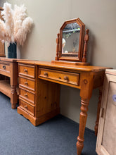 Load image into Gallery viewer, A charming solid pine dressing table in good condition, featuring four short dovetail-jointed drawers and one spacious long drawer for ample storage. The piece shows minor marks consistent with age and use, adding to its character. Includes an original mirror. Ideal for bedroom or dressing room settings where quality craftsmanship and practical storage are valued.

Delivery Available

Overall Dimensions

Dressing table : 110cm wide x 44cm deep x 76cm high


