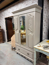 Load image into Gallery viewer, A stunning distressed satinwood wardrobe combining vintage appeal with practical storage. Featuring a sturdy hanging rail, multiple hooks, and a dovetail-jointed drawer, this piece offers generous capacity for your wardrobe essentials. The natural wear marks enhance its authentic charm, whilst the three-section design makes transportation and placement effortless. Ideal for those seeking quality vintage furniture with genuine character and functionality.

Delivery Available

Overall Dimensions

116cm wide x
