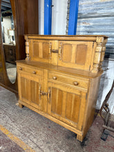 Load image into Gallery viewer, A characterful oak chiffonier offering generous storage across three sections: upper and lower double cupboards flanking two dovetail-jointed drawers. Structurally sound with the honest patina of age—minor marks consistent with vintage use. Ideal for dining rooms or hallways seeking both function and period charm.

Delivery Available

Overall Dimensions

131.5cm wide x 48cm deep x 126cm high&nbsp;

