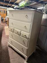 Load image into Gallery viewer, These substantial Stag drawers feature a sophisticated Oxford Stone finish from Farrow and Ball's renowned palette. The piece offers generous storage across seven drawers—four deep and three shallow—all constructed with traditional dovetail joinery for durability. In good overall condition with sound structure, this unit shows minor cosmetic wear to one side but nothing major.&nbsp;A practical, characterful addition to any room.

Delivery Available

Overall Dimensions

82cm wide x 46.5cm deep x 112.5cm high
