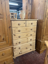 Load image into Gallery viewer, A charming solid pine chest of drawers with authentic character. This tall storage piece features a classic two-over-five drawer configuration with dovetail joinery—built to last. Stripped back to reveal natural pine grain, it's structurally sound and ready for your finishing touch. A protective wax coat will enhance both look and durability. Ideal for bedrooms, hallways, or any room needing generous storage with vintage appeal.

Delivery Available

Overall Dimensions

84cm wide x 42cm deep x 113cm high

